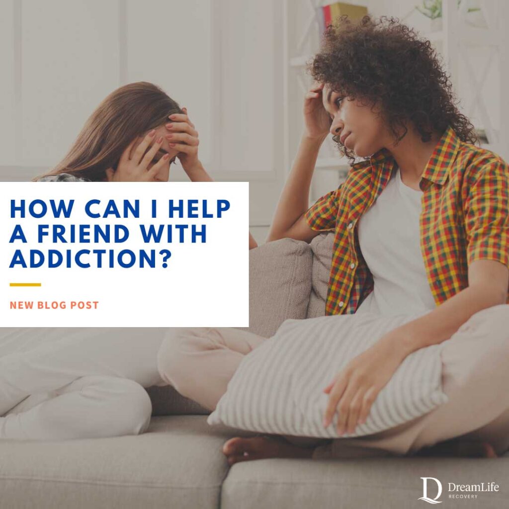 Two young women sit on a couch; one looks distressed with her head in her hands, while the other offers comfort. Text overlay reads, How can I help a friend with addiction? New blog post. DreamLife Recovery logo in corner.