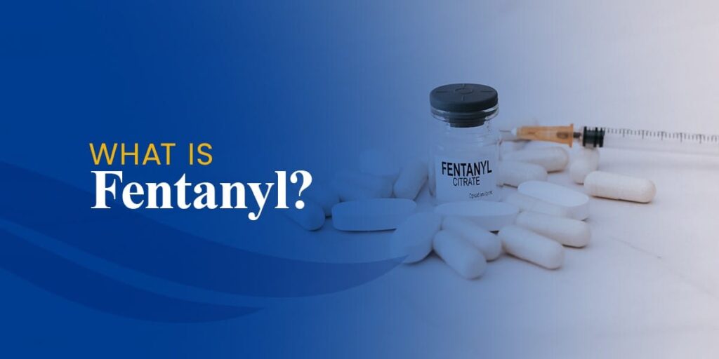 A small vial labeled Fentanyl Citrate sits among white pills and a syringe on a light surface. Text on the left reads What is Fentanyl? against a blue gradient background.