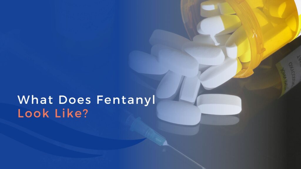 A spilled prescription bottle with white pills and a syringe beside text that reads What Does Fentanyl Look Like? on a blue background.