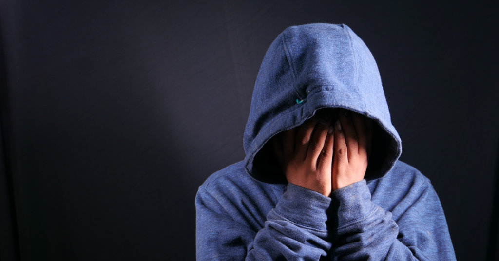 A person with a hood covering their face, representing an addict struggling more as their parents learn how to support an addict without enabling them.